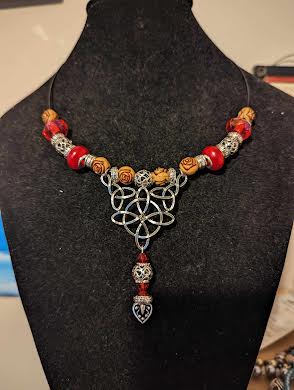 Celtic Knot with red and earth tone accent beads.